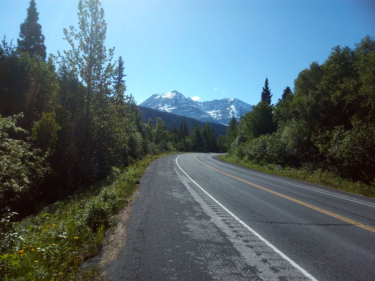 Paved road and Alaska mountains.
