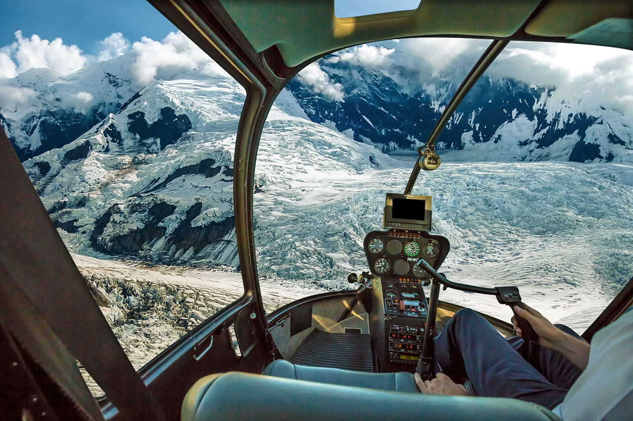 Inside a helicopter traveling through the mountains.